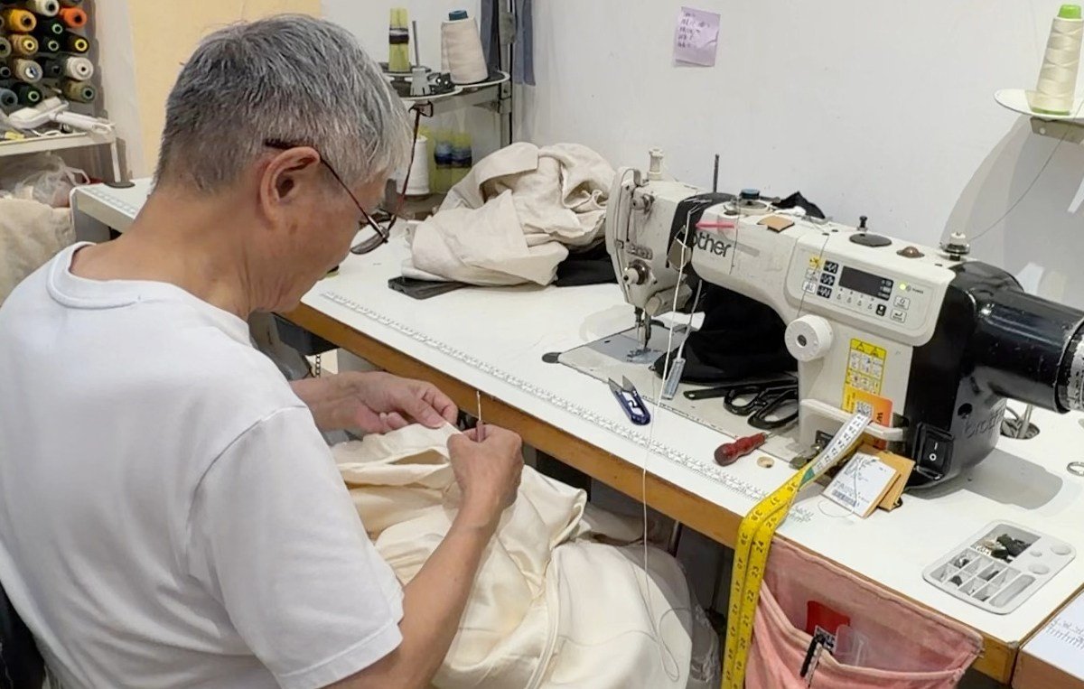 Master Hu hand-finishing a bespoke garment in the Shenzhen atelier