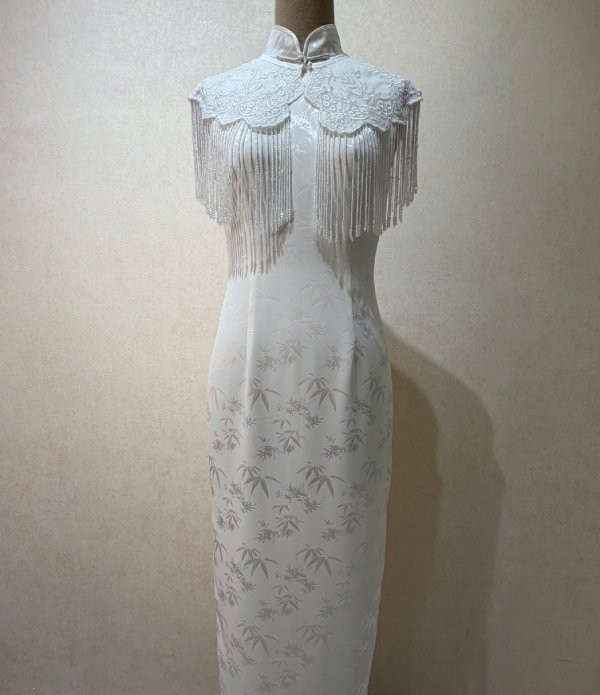 Imperial bamboo silk qipao with tasseled cape, an evening silhouette with hand-embroidered detail